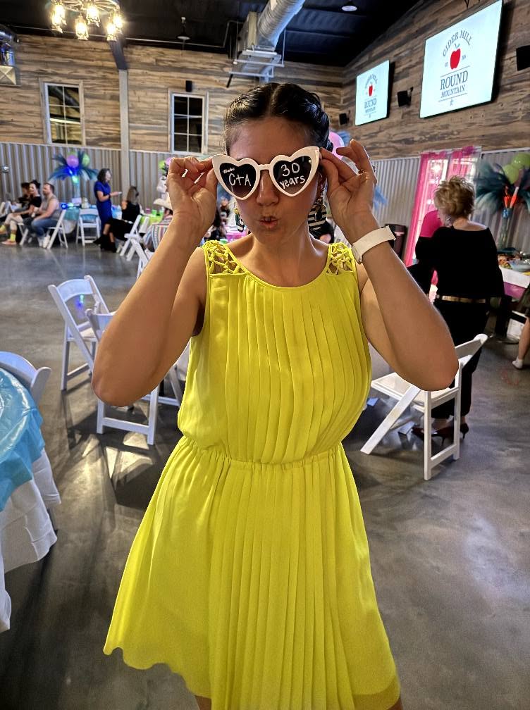 Ashley Billins smiling in a yellow dress